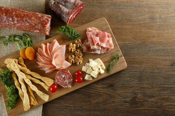 Cheese, parma ham, salami, sirloin, sausage with olives and spices on wooden board