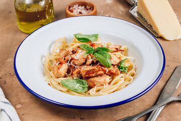 Spaghetti with chicken and basil in an enamel plate
