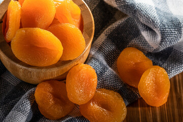 Dried apricots in bowl on fabric