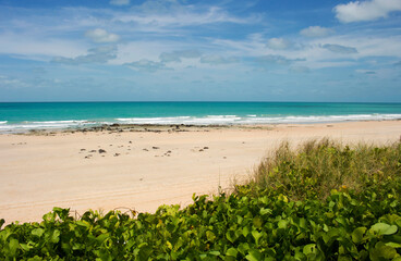 Waves rolling in as the tide ebbs out on a late morning in the Indian Ocean at Cable Beach, Broome ,North Western Australia in the Summer Wet Season create a delightful tropical seascape.