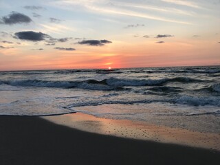 Fototapeta na wymiar Sunrise on the beach, pink and orange reflections 