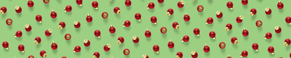 Christmas red decorations on green background. Christmas ornaments composition for background. Flat lay of red ornaments