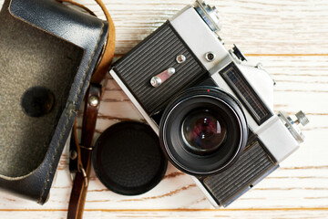A vintage full-frame camera on the wooden surface. A revival of retro photography