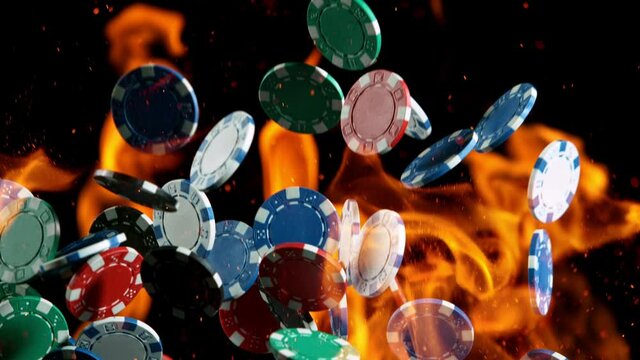 Poker chips with fire flames falling on casino table in super slow motion, filmed on high speed cinema camera at 1000 fps. Gambling background.