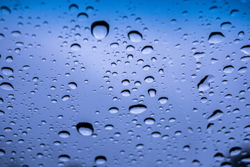 gotas de lluvia sobre el cristal, con el cielo azul de fondo