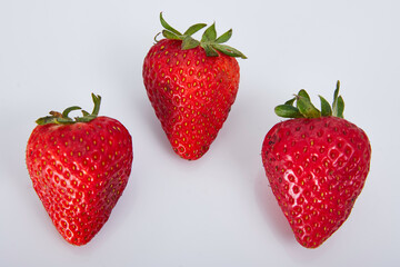 Delicious group of three strawberries, ripe and red