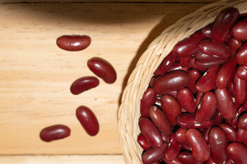 Red beans in a wicker basket on a wooden floor