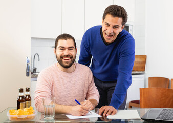 Men discuss and sign apartment sale contract agreement at home. High quality photo