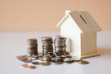 Saving piggy bank wooden house on the floor Has a light pink background Convey to savings