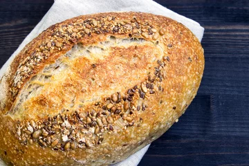 Rollo Brot Rye bread with sunflower seeds and flax seeds on a dark wooden background. Fresh bread. Close-up. View from above. Copy space for text.  ©  Iryna	
