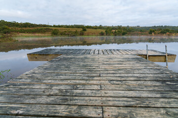 wooden pier on artificial lake in the mountains