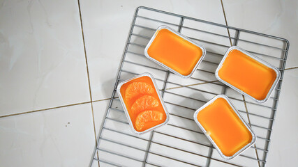 orange glazed cakes in the rectangular boxes on the oven rack, one being different from the others