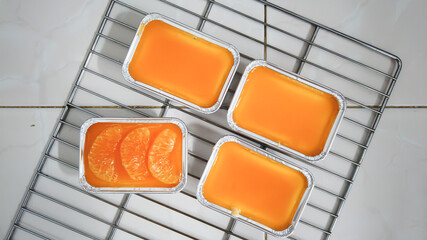 orange glazed cakes in the rectangular boxes on the oven rack, one being different from the others