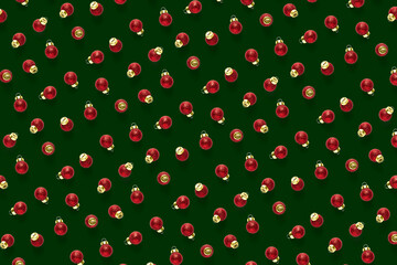 Christmas red decorations on green background. Christmas ornaments composition for background. Flat lay of red ornaments