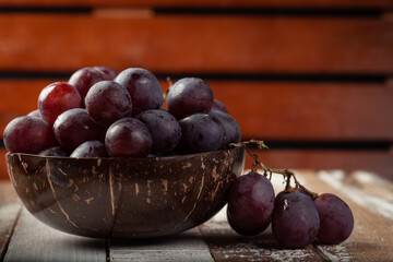 uvas frescas em um pote de madeira
