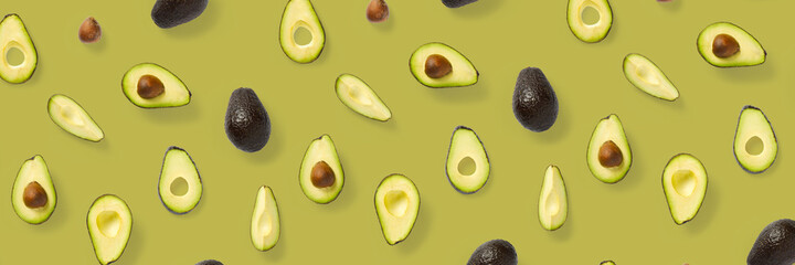 Avocado banner. Background made from isolated Avocado pieces on olive color background. Flat lay of fresh ripe avocados and avacado pieces.