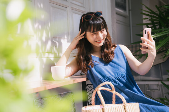 Woman doing vlog with smartphone outdoors.