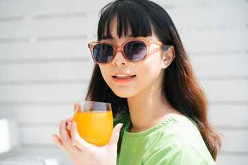 Beautiful asian woman with sunglasses and orange juice.