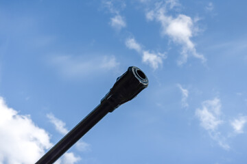barrel of an artillery piece against a blue sky close-up