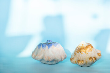 White and gold pumpkins - Halloween decoration on blue background. Thanksgiving composition on Modern autumn styled. Trendy holiday concept.