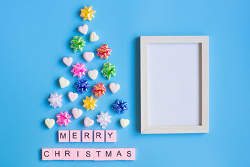 Merry Christmas composition and Photo frame on blue background. Christmas and winter concept. Flat lay, top view, copy space.
