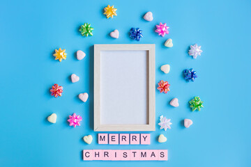 Merry Christmas composition and Photo frame on blue background. Christmas and winter concept. Flat lay, top view, copy space.