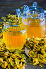 Chinese Chrysanthemum Tea in cup and  teapot on wood table, health herbal tea.