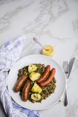 Oldenburger Grünkohl mit Pinkel, Kohlwurst, Senf und Kartoffeln auf Marmor Tisch