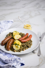 Oldenburger Grünkohl mit Pinkel, Kohlwurst, Senf und Kartoffeln auf Marmor Tisch