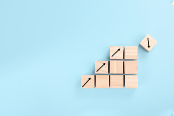 the concept of risk in business. growth on stacked wooden cubes on blue background. Financial or business growth concept. arrows icons on wooden cubes
