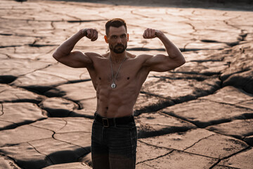 Attractive tanned man on the black sand