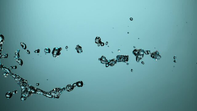 Water splashing on blue background, super slow motion. Filmed on high speed cinema camera, 1000 fps.