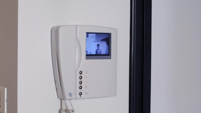 White Video Intercom that Turns on at the Ringing of the Doorbell and Response from a Man