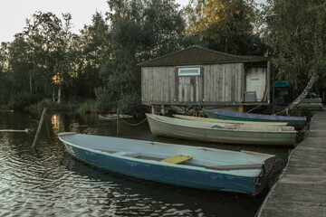 Fototapeta na wymiar Wooden boats by the pier with fisherman's house in the evening.