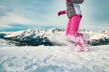 Girl with skiwear and helmet on her head, has fun playing in the snow.