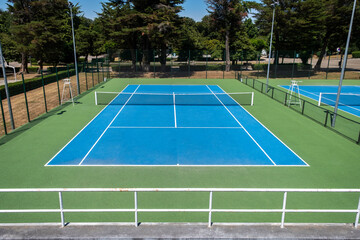 Outdoor tennis court painted in blue and green. Sports concept.