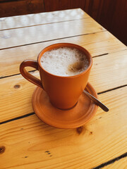 coffee in a clay cup on a wooden table