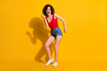 Full length body size view of her she nice attractive lovely glamorous cheerful cheery funky wavy-haired girl dancing night club having fun isolated bright vivid shine vibrant yellow color background