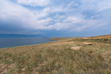 Picturesque sky over the Maloye More Strait. Federal highway on the steppe coast of Olkhon Island.