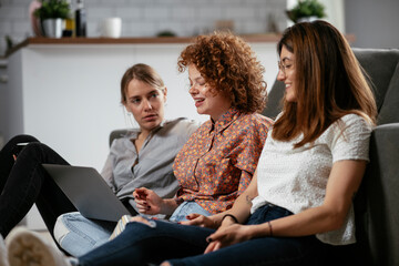 Girlfriends talking and laughing in office. Beautiful women drinking coffee in the office...