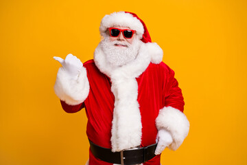 Portrait of his he nice attractive cheerful cheery confident fat Santa presenting copy space way direction choose choice shopping isolated over bright vivid shine vibrant yellow color background
