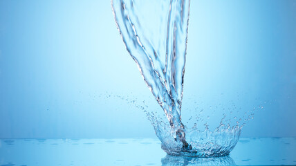 Fototapeta na wymiar Pouring water on blue background