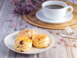 Side view of traditional British scones and cookie with a white coffee cup