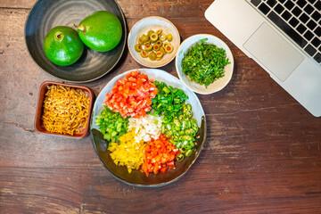 Top view of preparing cooking for loaded minced pork nachos with guacamole and salsa dips