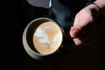Barista prepares coffee in a paper cup