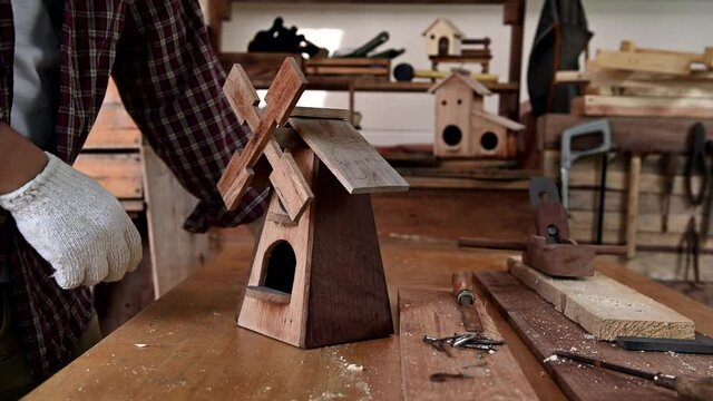 Man daily lifestyle at home. Woodworking and DIY vintage wooden bird house for garden decoration. Carpenter and craftsman workshop.