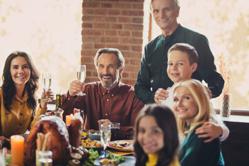 Photo of festive served table family event greeting toast raise wineglasses friendly relatives living room indoors