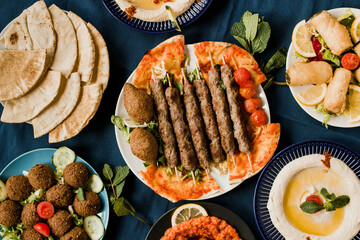 Traditional Arab cuisine including kebab meat, kibbeh, mutabal, falafel, muhammara, pita bread and hummus