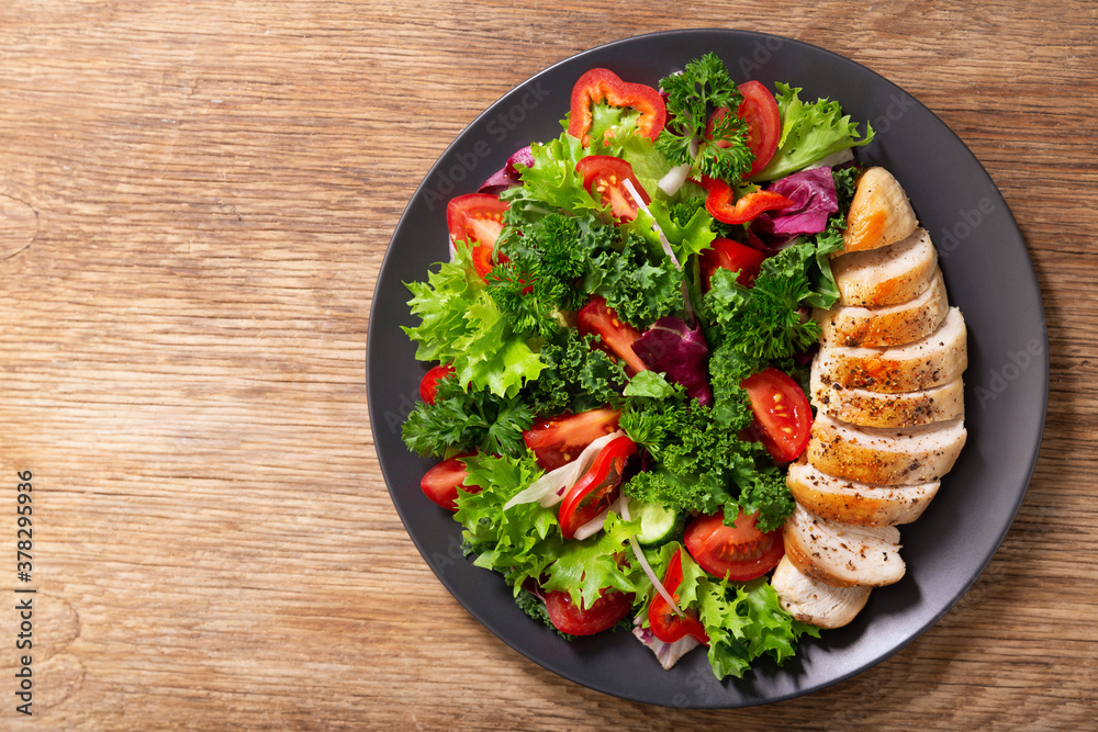 Poster plate of chicken salad with vegetables, top view