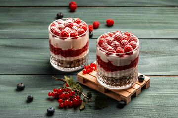 Raspberry dessert, cheesecake, trifle, mouse in a glass on a wooden background. sweet raspberry...